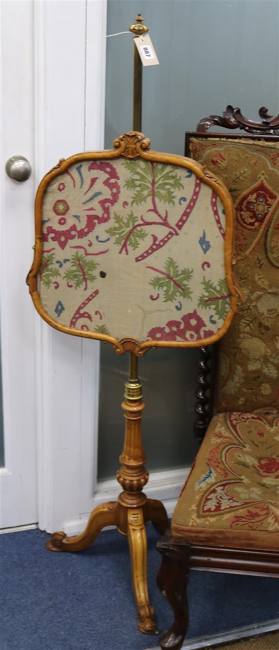 A Victorian maple pole firescreen, with adjustable brass tubular stem on reeded tripod base, supporting a H.4ft 5in.